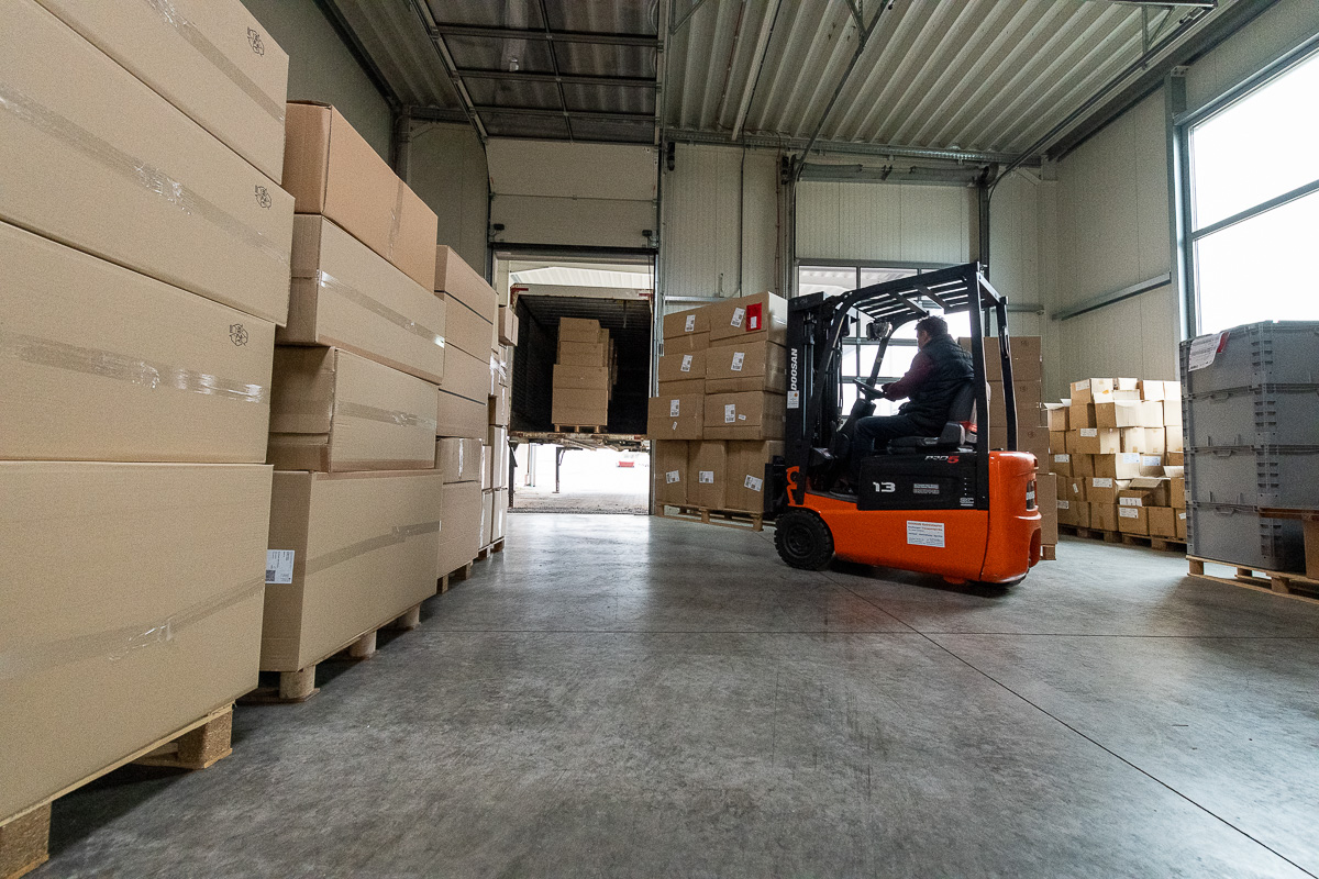 Kartons mit Kunststoffboxen werden per Gabelstapler in einen LKW geladen.